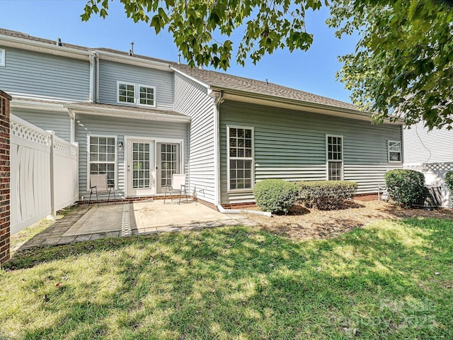 back of house with a yard and a patio