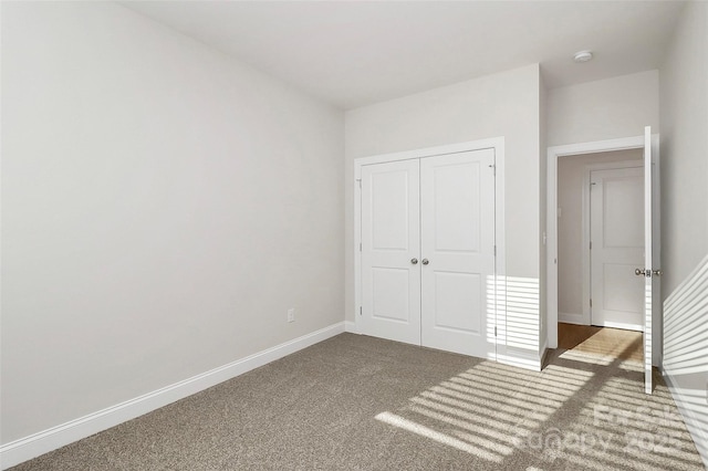 unfurnished bedroom featuring carpet flooring and a closet