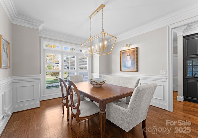 dining room featuring crown molding, dark wood-type flooring, and a chandelier