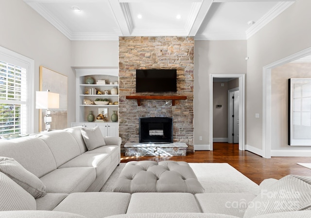 living room with beamed ceiling, a stone fireplace, dark wood-type flooring, and built in features