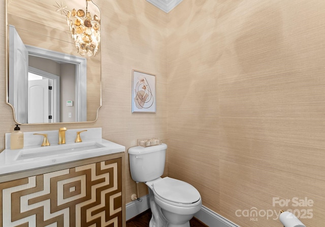 bathroom with vanity, an inviting chandelier, and toilet