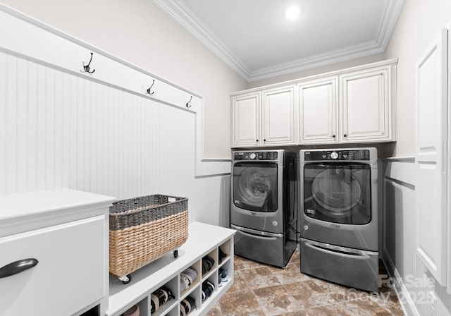 laundry area with separate washer and dryer, crown molding, and cabinets