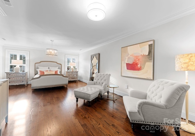 bedroom with dark hardwood / wood-style flooring, ornamental molding, and a chandelier