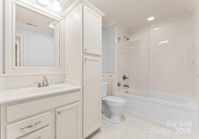 full bathroom featuring tile patterned floors, toilet, tiled shower / bath, ornamental molding, and vanity