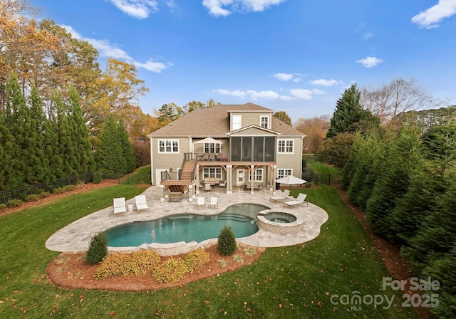 rear view of house featuring a swimming pool with hot tub, a sunroom, a lawn, and a patio area