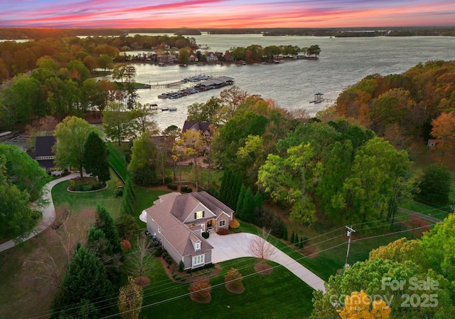 aerial view at dusk featuring a water view