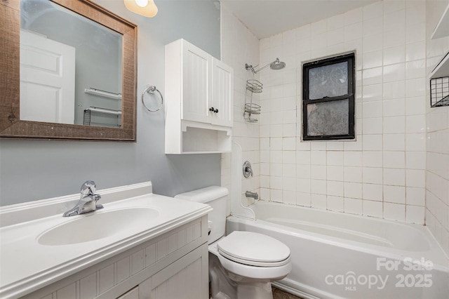 full bathroom with vanity, tiled shower / bath combo, and toilet