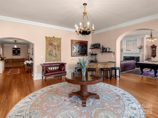 dining area featuring hardwood / wood-style floors, ornamental molding, billiards, and a premium fireplace