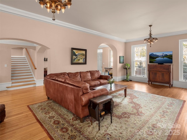 living room featuring light hardwood / wood-style floors, an inviting chandelier, and ornamental molding