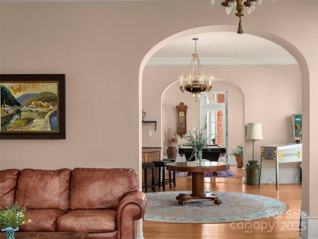 living room featuring hardwood / wood-style floors, crown molding, and a chandelier