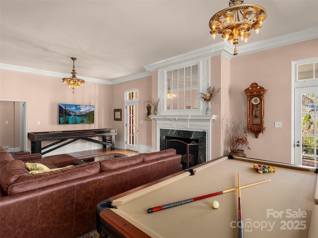 interior space with a premium fireplace, crown molding, billiards, and a chandelier