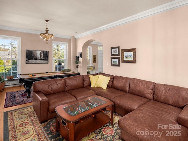 living room with crown molding, pool table, light hardwood / wood-style floors, and a notable chandelier