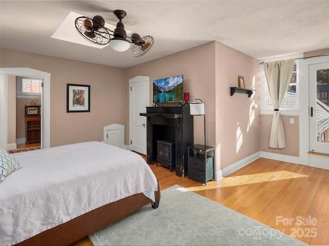 bedroom with access to exterior, hardwood / wood-style floors, and ceiling fan