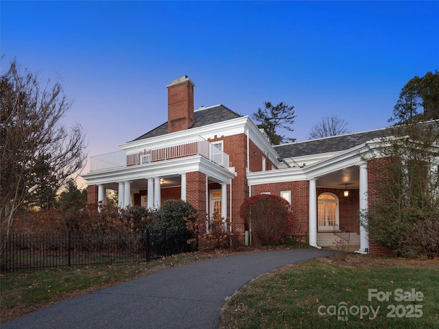 property exterior at dusk with a balcony