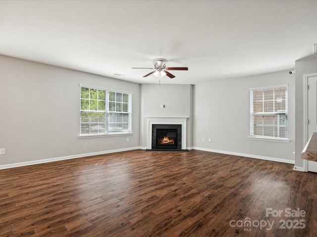 unfurnished living room featuring dark hardwood / wood-style floors and ceiling fan