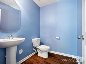 bathroom featuring hardwood / wood-style floors, toilet, and sink