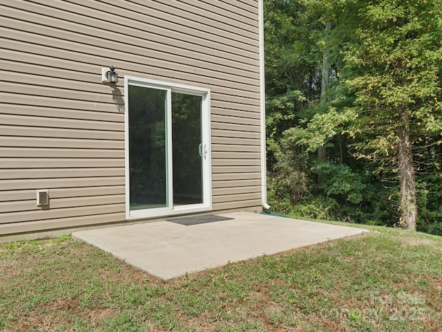 doorway to property featuring a lawn and a patio