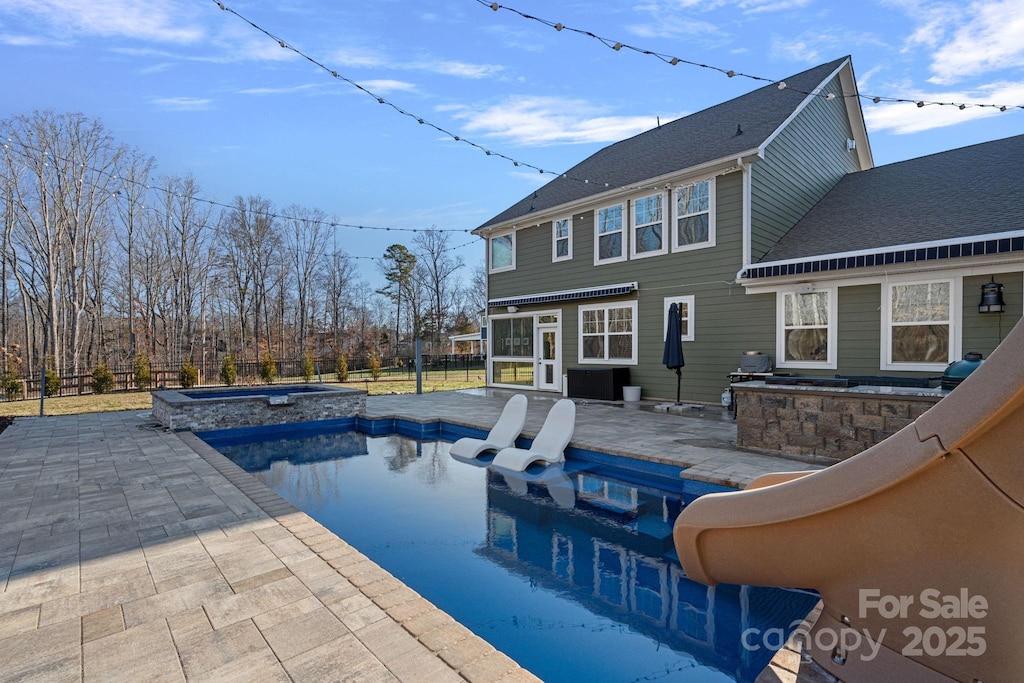 view of pool with an in ground hot tub and a patio