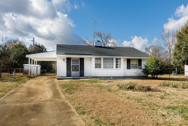 ranch-style home featuring a front lawn and a carport