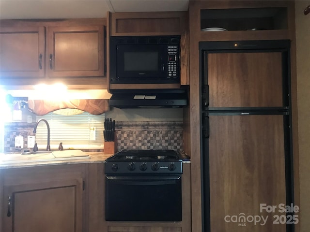 kitchen featuring decorative backsplash, exhaust hood, sink, and black appliances