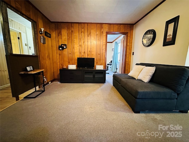 living room with carpet flooring, crown molding, and wooden walls