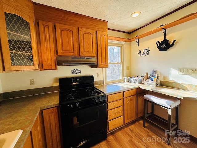 kitchen with crown molding, sink, light wood-type flooring, a textured ceiling, and black range with gas cooktop