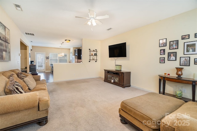 carpeted living room with ceiling fan