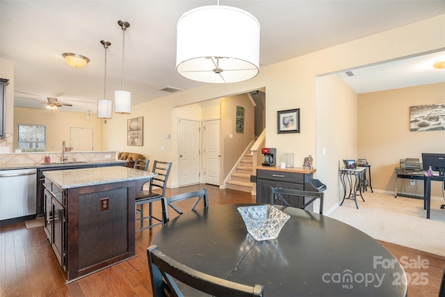 dining area with ceiling fan, dark hardwood / wood-style flooring, and sink