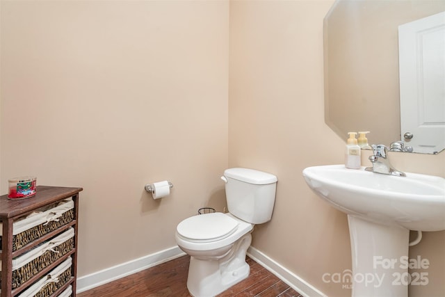 bathroom with toilet, wood-type flooring, and sink