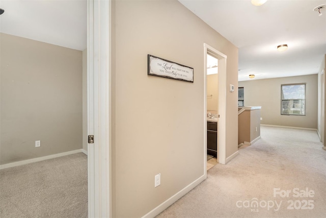 hall featuring light colored carpet