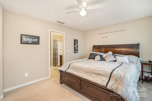 carpeted bedroom with ensuite bathroom and ceiling fan