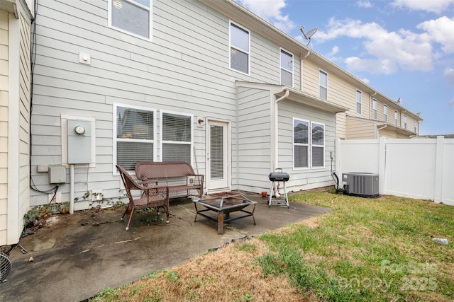 back of house featuring a yard, a fire pit, a patio area, and central air condition unit