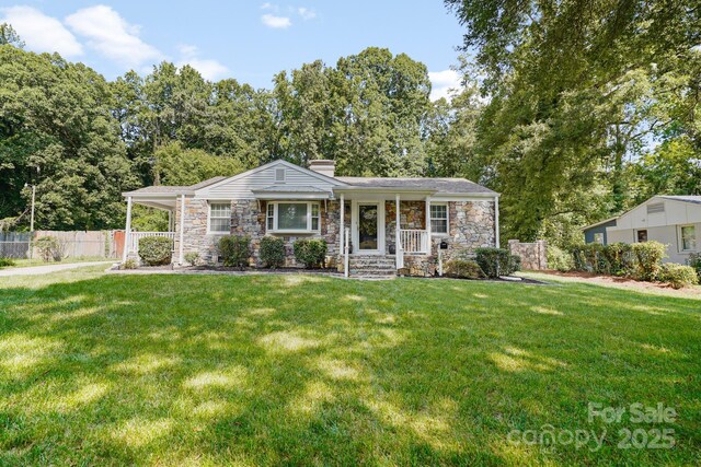 ranch-style home with covered porch and a front yard