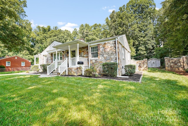 view of front of house with a porch, a shed, and a front lawn