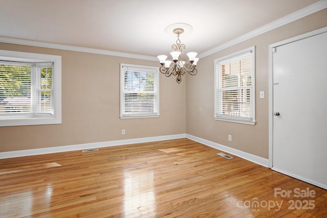 unfurnished room with light wood-type flooring, ornamental molding, and a chandelier