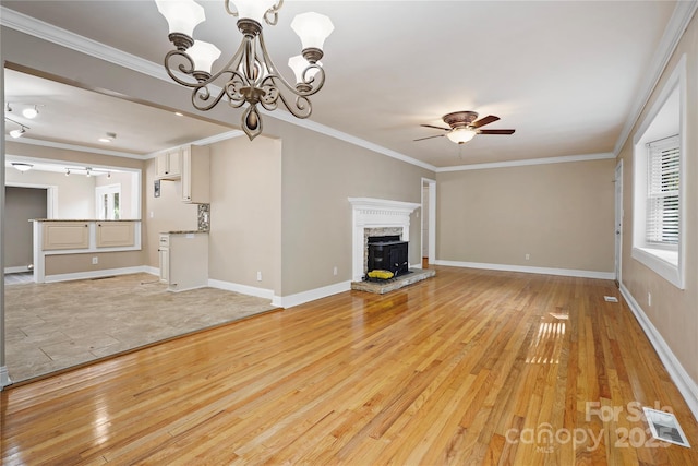 unfurnished living room featuring ceiling fan with notable chandelier, light wood-type flooring, and ornamental molding