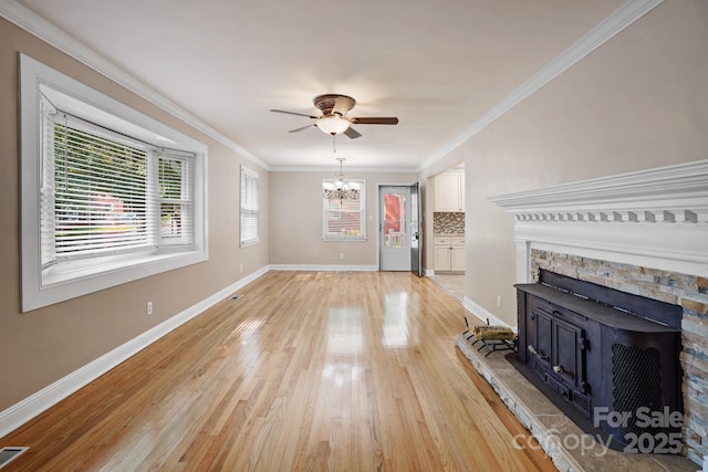 unfurnished living room featuring light hardwood / wood-style floors, ceiling fan with notable chandelier, and ornamental molding