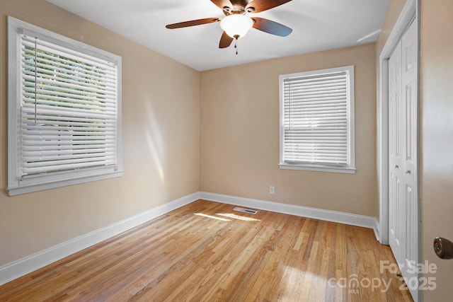 unfurnished bedroom featuring ceiling fan, light hardwood / wood-style floors, and a closet