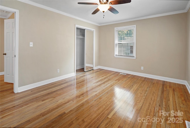 unfurnished bedroom featuring ceiling fan, light hardwood / wood-style floors, ornamental molding, and a closet