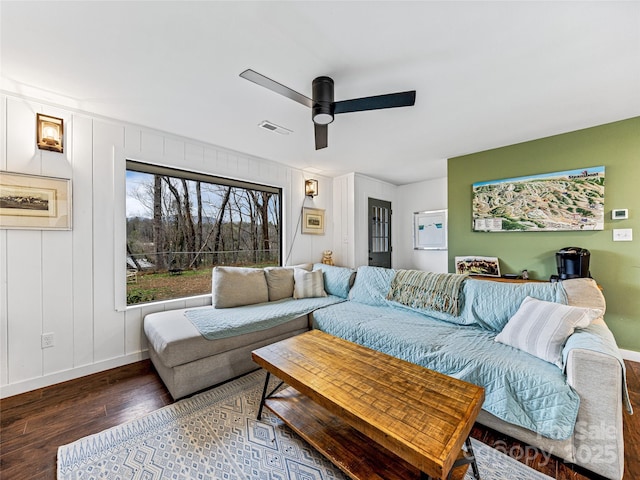 living room with ceiling fan and dark wood-type flooring