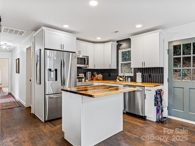 kitchen featuring wooden counters, stainless steel appliances, white cabinets, and dark wood-type flooring