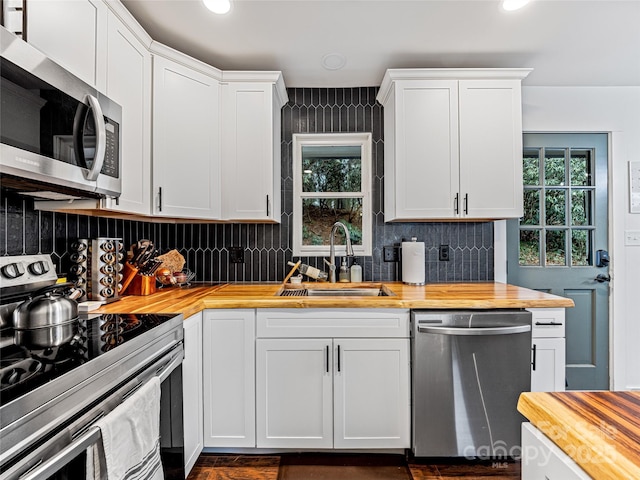 kitchen featuring wood counters, sink, white cabinets, and appliances with stainless steel finishes