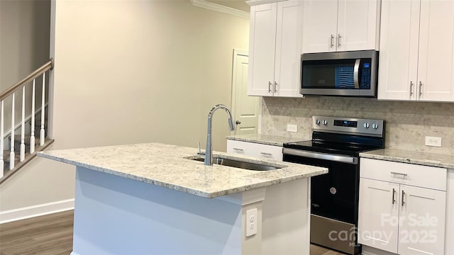 kitchen featuring white cabinetry, stainless steel appliances, sink, and a center island with sink