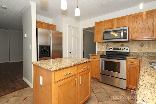 kitchen featuring pendant lighting, light tile patterned flooring, stainless steel appliances, and tasteful backsplash