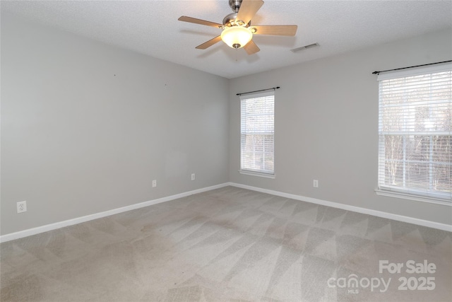 carpeted empty room with ceiling fan and a textured ceiling