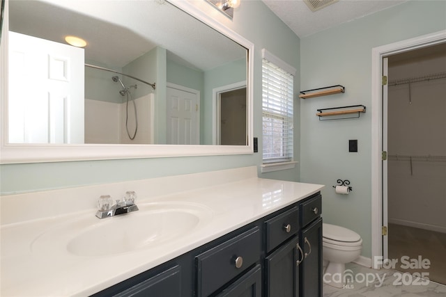 bathroom featuring vanity, a textured ceiling, a shower, tile patterned flooring, and toilet