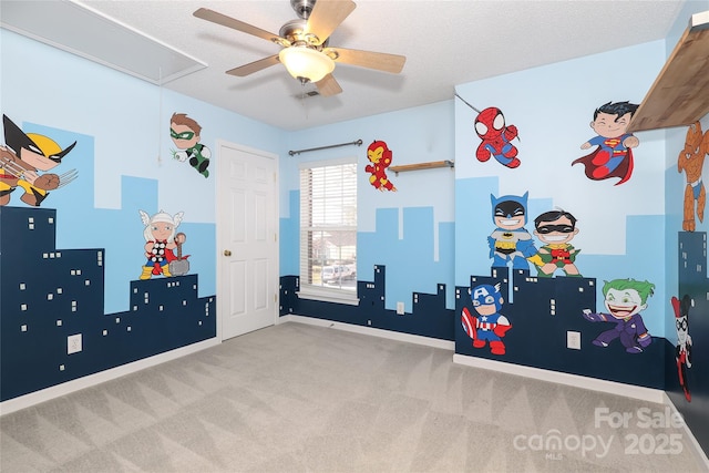 playroom with ceiling fan, light colored carpet, and a textured ceiling