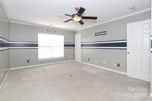 empty room featuring a textured ceiling, ceiling fan, crown molding, and light carpet