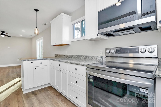 kitchen with decorative light fixtures, kitchen peninsula, white cabinetry, light hardwood / wood-style flooring, and stainless steel appliances