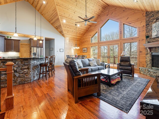 living room with a fireplace, dark hardwood / wood-style floors, high vaulted ceiling, and wooden ceiling